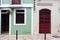 The entrance to the house with a red door leads to the entrance from the old stone-paved street.