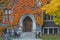 Entrance to ivy covered gothic stone college building with fall colors