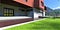 Entrance to a newly built house in the mountains after a light rain. Green grass, red brick pavers. Garage with automatic lifting