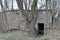 Entrance to old concrete pillbox bunker or fallout shelter among trees