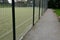 Entrance to the outdoor playground with carpet artificial turf. Rural school playground in the park with benches and gravel paths