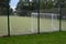 Entrance to the outdoor playground with carpet artificial turf. Rural school playground in the park with benches and gravel paths