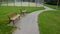 Entrance to the outdoor playground with carpet artificial turf. Rural school playground in the park with benches and gravel paths