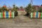 Entrance to the playground with green pines and colored wooden decorative fence