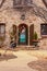 Entrance to rock house with pretty Christmas decorated front door and curving sidewalk