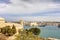 Entrance to the Valletta city harbor at Malta, with many historic buildings along the coastline