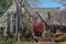 Entrance to wood shingled house with Japanese Maple and wooden shutters and vines growing on the wall in early spring