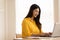 Entrepreneur beautiful business asian young woman wear yellow shirt work online with laptop at home.Freelance woman working online