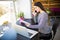 Entrepreneur calling on phone and working on line with a laptop sitting in a desk at office