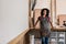 Entrepreneur leaning against a workbench in her framing studio