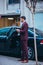 EntrepreneurBusinessman standing in an urban area and wearing a suit and tie next to his limo while talking on the phone