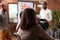 Entrepreneurs sitting at meeting table in startup company office brainstorming business