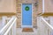 Entryway of a home with stairs leading to the porch and blue front door