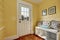 Entryway with yellow walls and storage bench in white