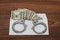 Envelope with dollars on a wooden background. Steel handcuffs on the envelope.