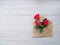 envelope of Kraft paper, with flowers red roses on a wood background, space for text, as congratulation wedding, birthday