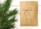 Envelope packed in kraft paper and bandaged with linen tape. Blank letter for holiday greetings on a white wooden background.