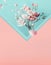 Envelope with pink white spring blossom branches and flying petals. Creative spring time layout in pastel color.