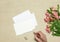 Envelope and postcard with flowers on stone background