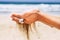 Environment and respect for the nature with close up of woman hands taking sand falling down - beach and blue sky ocean water in