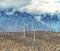 Environmental green power windmills dot a hill in the desert.