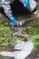 Environmental laboratory specialist in protective suit and mask in a gutter pours water into a flask to study the level of