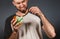 Environmental pollution and food industry. Close up portrait of a man with a beard, who puzzled pulls the thread from the filling