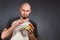 Environmental pollution and food industry. Portrait of a bald man with a beard, who puzzled pulls polyethylene from the filling in