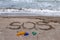 Environmental problem. Ecology concept. Plastic on the beach with sos writing. Spilled garbage on the beach