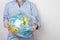 Environmental protection. Tarnishing the planet. A woman holds in her hands the planet Earth in the form of a globe in a