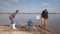 Environmental solutions, child boy helps mother and father volunteer activists clean up dirty river shore from plastic