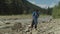 Environmentally aware arab man volunteer carrying garbage bag with plastic waste in mountains