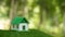 Environmentally eco-friendly real estate house. Small model building property home on grass in green nature ecology. Sustainable