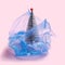Environmentally issue inspired concept. Open plastic blue disposable blue bag. Glitter silver artificial Christmas tree with red