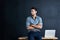 Envisioning how to start his next big success story. a handsome young businessman standing in front of a desk against a