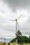 Eolian field and wind turbines farm, near yellow fllowers field, clouds blue sky