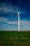 Eolian turbine with big propellers used to produce green energy seen from a wheat field in the spring