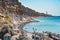 Eople swimming and sunbathing at beach near white rocks of Vlychada town of Santorini island