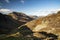 Epic Autumn Fall landscape image of Haystacks and High Stile mountain peaks in Lake District with gorgeous light across ridge