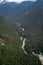 epic capture of bending river surrounded by alpine landscape of trees and mountains during the day from above