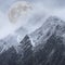 Epic digital composite image of Supermoon above mountain range giving very surreal fantasy look to the dramatic landscape image