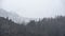 Epic dramatic landscape image of view from Elterwater across towards Langdale Pikes mountain range on foggy Winter morning