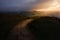 Epic early sunrise over the Peak District National Park showing the only path through the lush hills