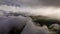 Epic hyperlapse aerial view low flying above the clouds at sunset in the mountains. Beautiful rays of the sun break