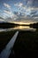 An epic lake view in Sweden near GlommerstrÃ¤sk. with open and cloudy sky and reflecting lake surface and a setting sun