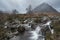 Epic landscape image of Buachaille Etive Mor waterfall in Scottish highlands on a Winter morning with long exposure for smooth