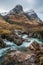 Epic landscape image of vibrant River Coe flowing beneath snowcapped mountains in Scottish Highlands