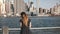 Epic panning shot of happy smiling Caucasian woman with flying hair enjoying famous New York City riverside skyline view
