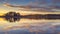 Epic red sunset sky above the lake and forest. Dramatic cloudscape. Symmetry reflections on the water, natural mirror