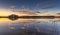 Epic red sunset sky above the lake and forest. Dramatic cloudscape. Symmetry reflections on the water, natural mirror